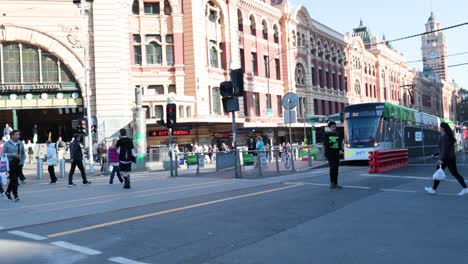 people crossing street near victorian train station