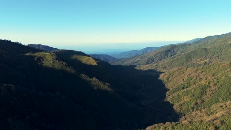 Drone-footage,-where-a-portion-of-the-majestic-mountain-range-of-Yunga-captured-with-light-blue-sky-and-beautiful-sunset-rays