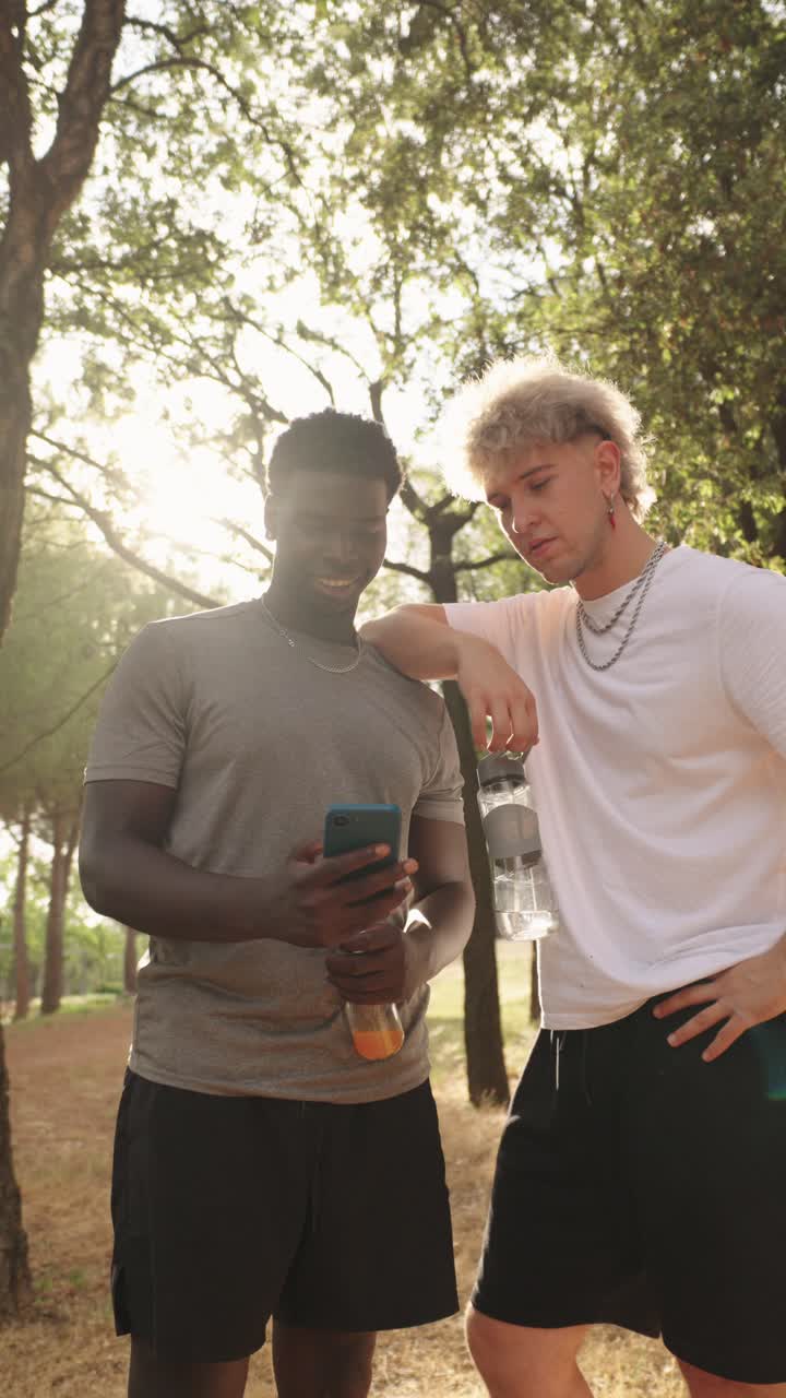 Two Men Outdoors with Smartphone and Water Bottle