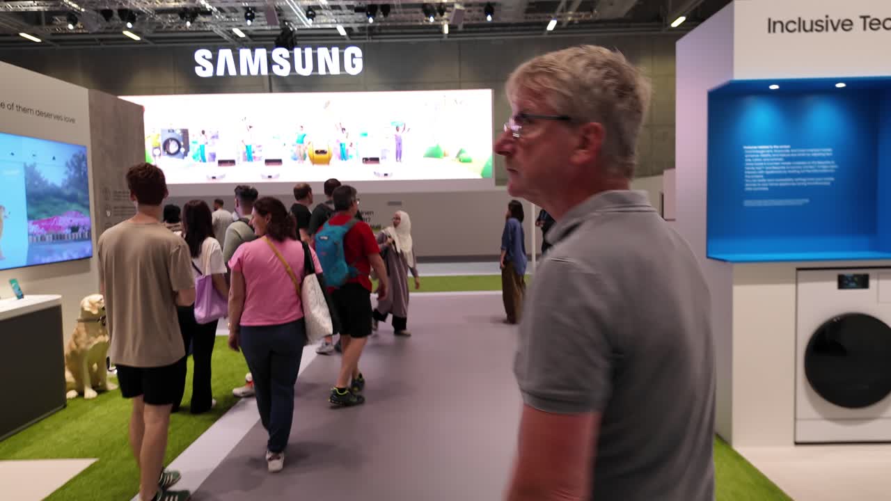 Visitors explore the Samsung exhibition space at IFA Berlin, showcasing advanced technology and inclusive innovation. Crowds interact with displays under vibrant lighting