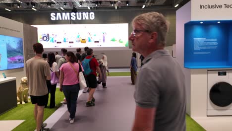 visitors explore the samsung exhibition space at ifa berlin, showcasing advanced technology and inclusive innovation. crowds interact with displays under vibrant lighting