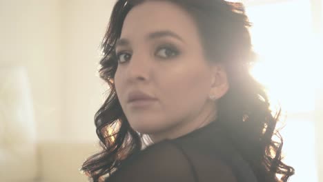 closeup-woman-with-makeup-and-dark-hair-poses-in-room