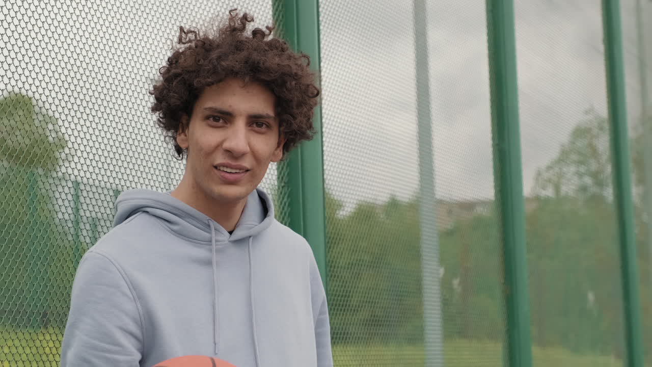 Man with curly hair and basketball