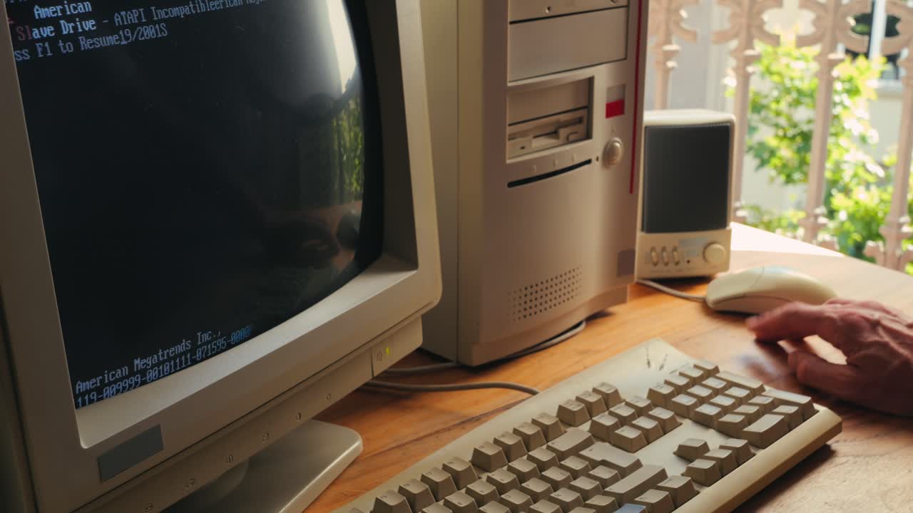 Man working and gaming on retro computer PC, IT engineer with vintage computer at home, using old fashion technology, close up of retro setup.