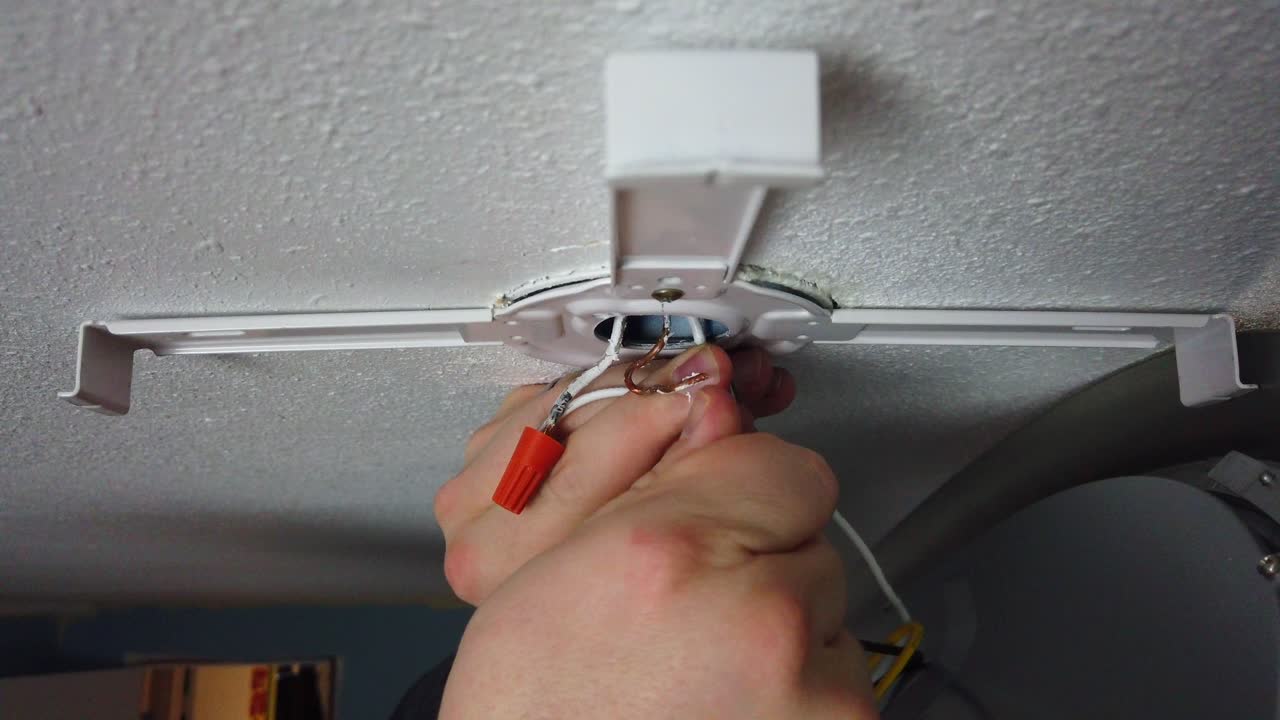 Twisting a few wire nuts together connecting the wires of a new LED light install