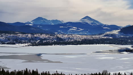 downtown frisco toward breckenridge colorado aerial cinematic drone lake dillon marina keystone summit cove cloudy snowy winter morning view silverthorne ten mile range calm unfrozen ice upwards