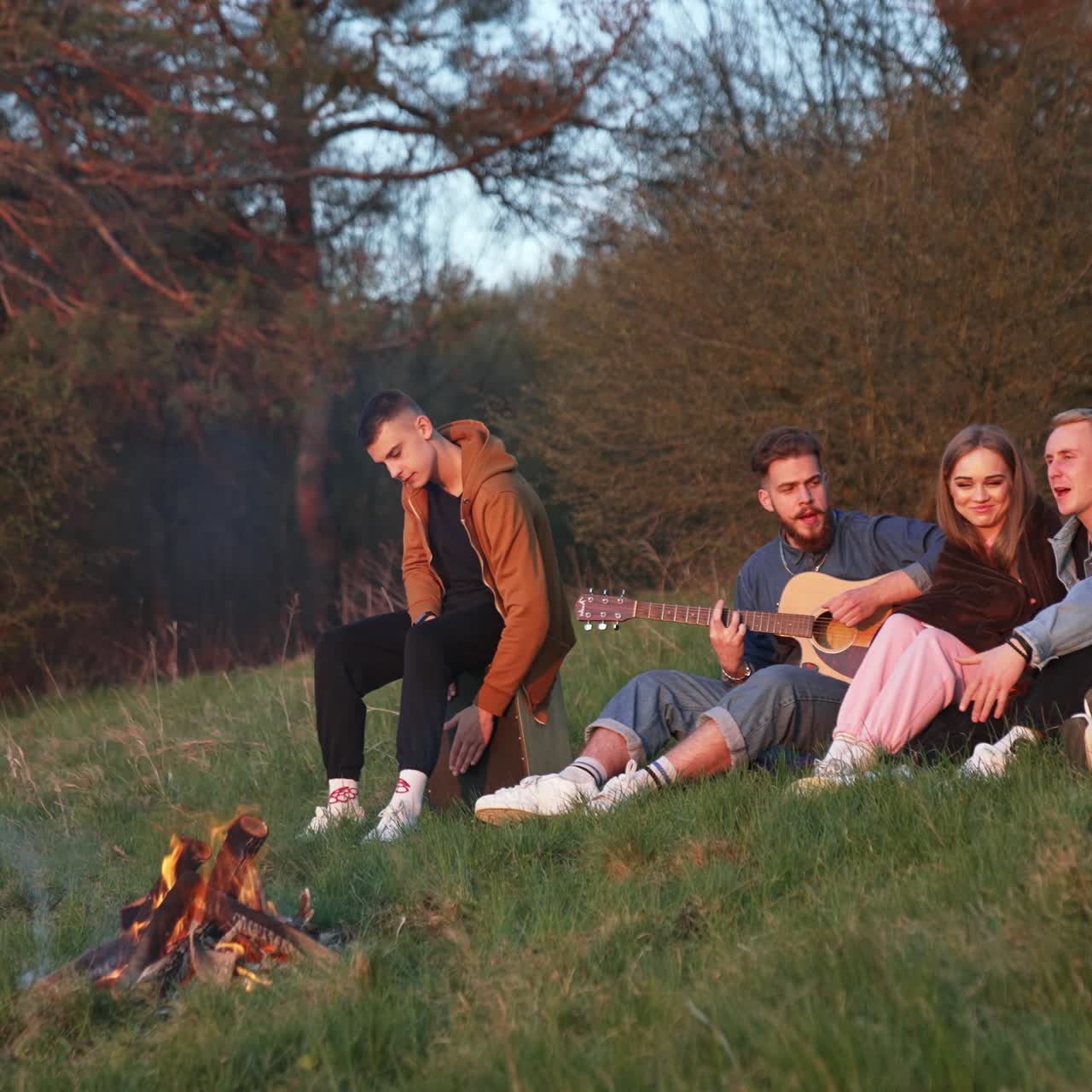 Friendship playing guitar near campfire. Campfire outdoor concept of friends holiday lifestyle