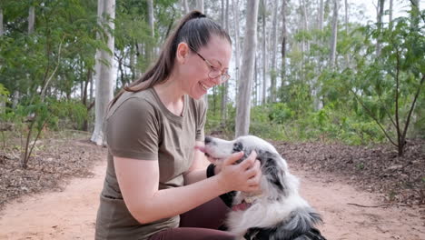 Young-attractive-woman-having-fun-with-her-Australian-shepherd,-both-look-happy