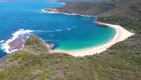 Drone-aerial-landscape-pan-shot-of-Maitland-Bay-Bouddi-National-Park-ocean-water-bushland-coastline-NSW-travel-tourism-Central-Coast-Australia-4K