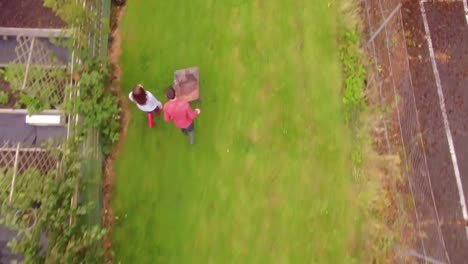 Drone-footage-of-gardener-pushing-wheelbarrow