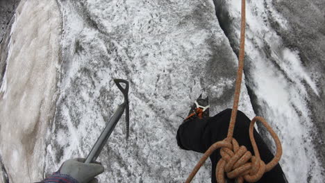 an alpinist is walking on a glacier in switzerland to find crystal with all his equipement, rope