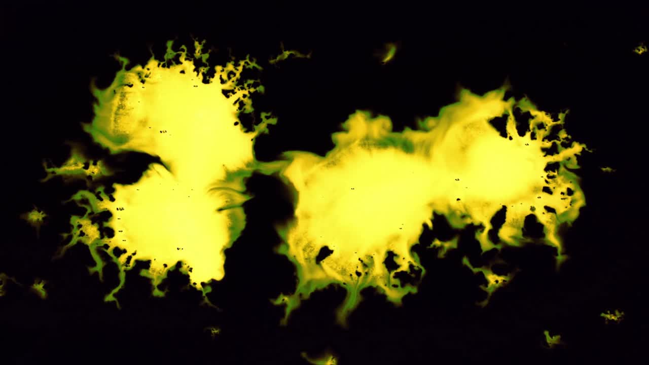 Inchiostro astratto giallo e verde che si diffonde su sfondo nero