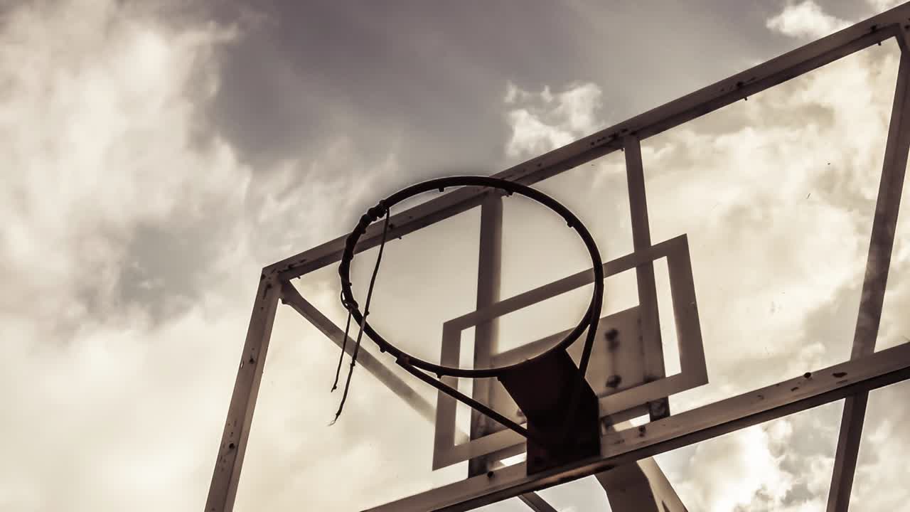el fondo de la nube dramáticamente en movimiento de un anillo de baloncesto en color cálido