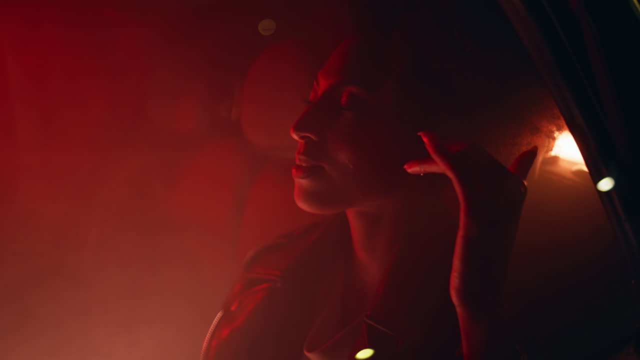 Car passenger relaxing backseat illuminated neon light closeup. woman