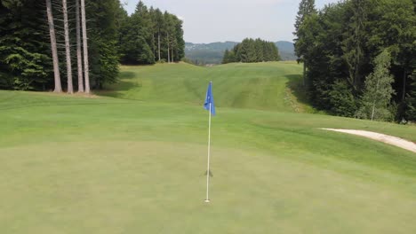 Bandera-Azul-En-Un-Hoyo-De-Golf-En-Un-Hermoso-Campo-De-Golf-En-Medio-Del-Bosque