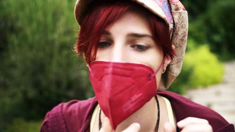 close up of vintage woman putting on a red ffp2 mask to protect from corona virus threat