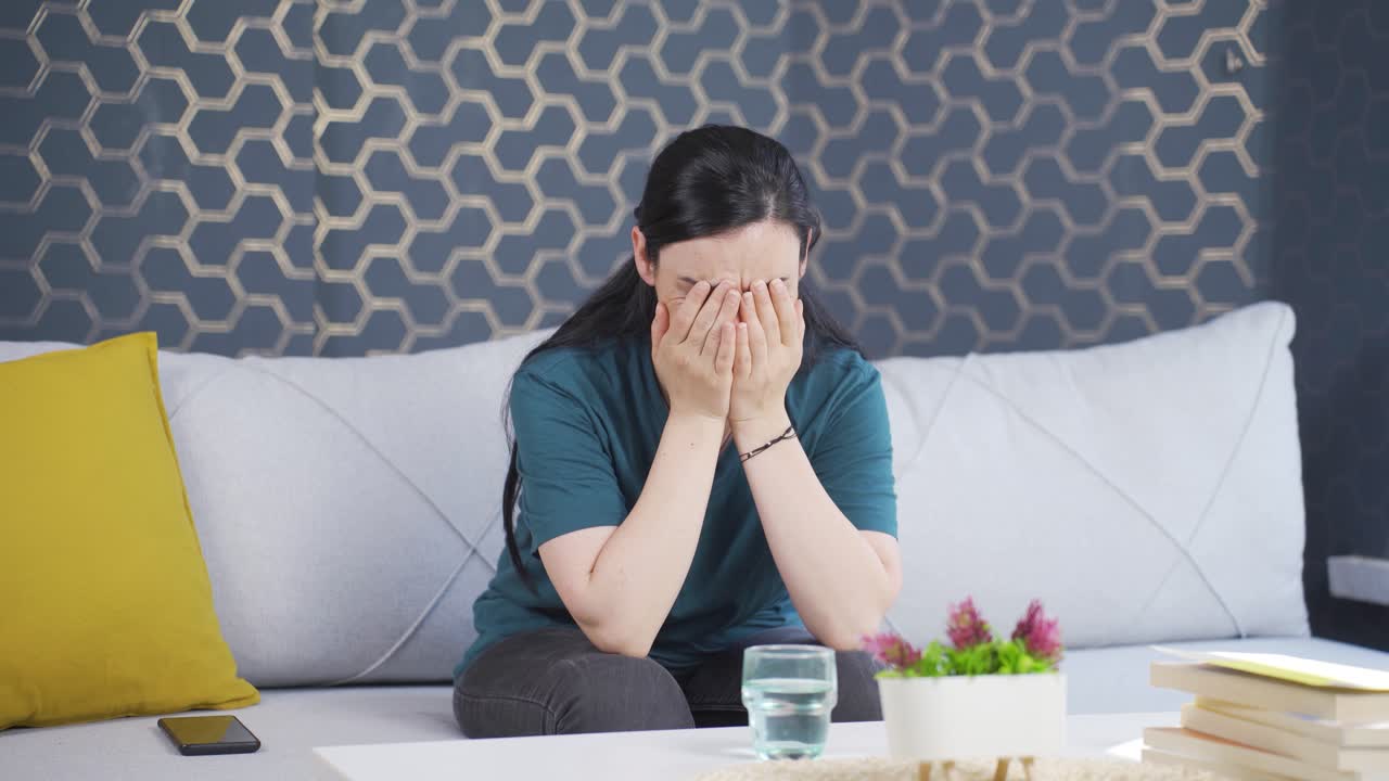 집에서 혼자 울고 있는 여자.