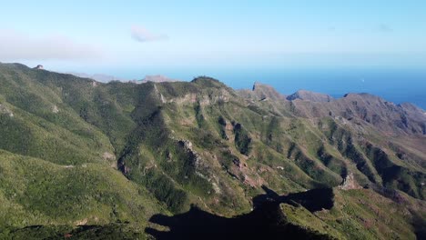 Drone-flight-towards-exotic-mountain-ridge.-The-high-hills-covered-with-greenery.-Camera-moves-pass-the-ledge-and-overlooks