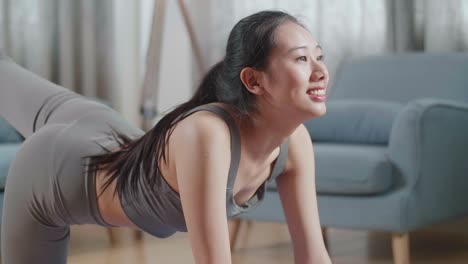 close up portrait of young asian athletic female exercising, stretching and practicing yoga at home. healthy lifestyle, fitness, wellbeing and mindfulness concept