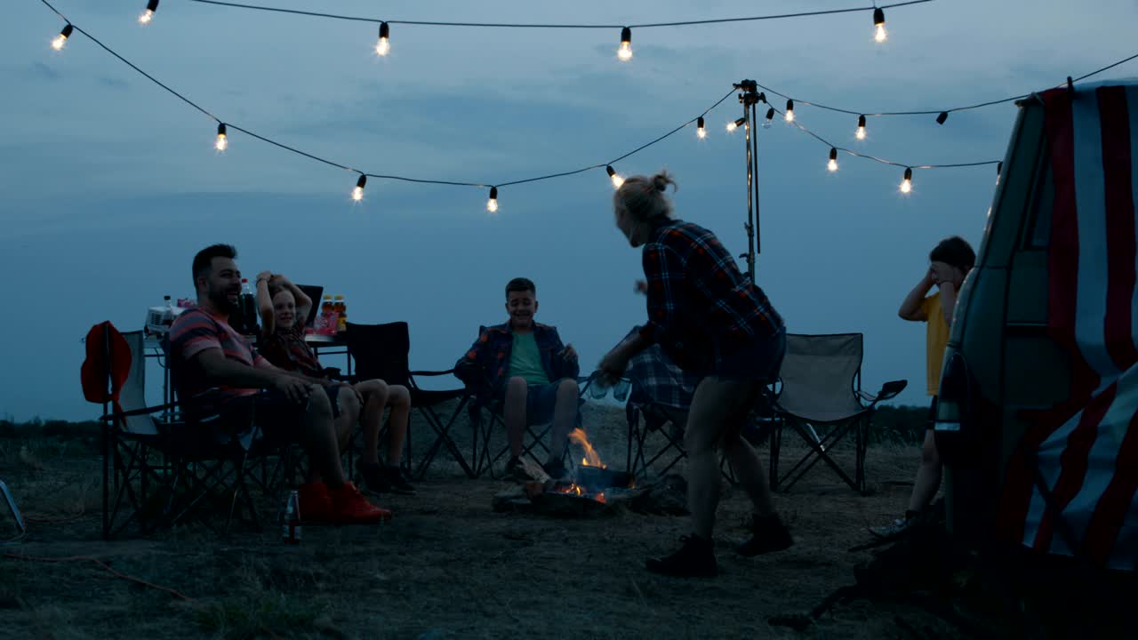 밴 근처 에 있는 캠핑장 에서 가족 들 이 즐겁게 지내고 있다