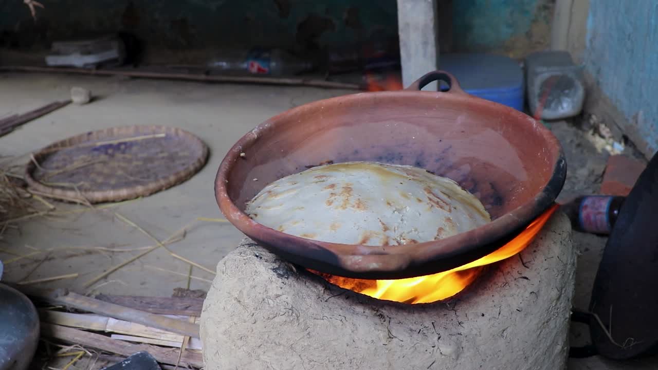 hacer pan de arroz en recipientes de suelo tradicionales al fuego de madera desde diferentes ángulos