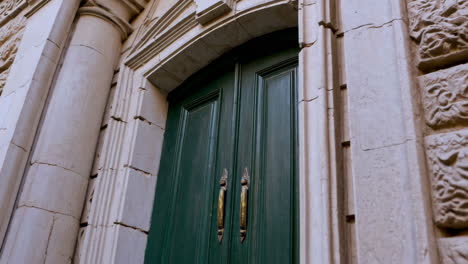 ornate stone archway and green door of an old building