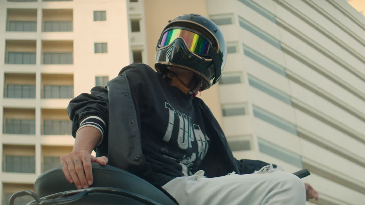 Stylish Man in Helmet Sitting on Motorcycle in Urban City Setting