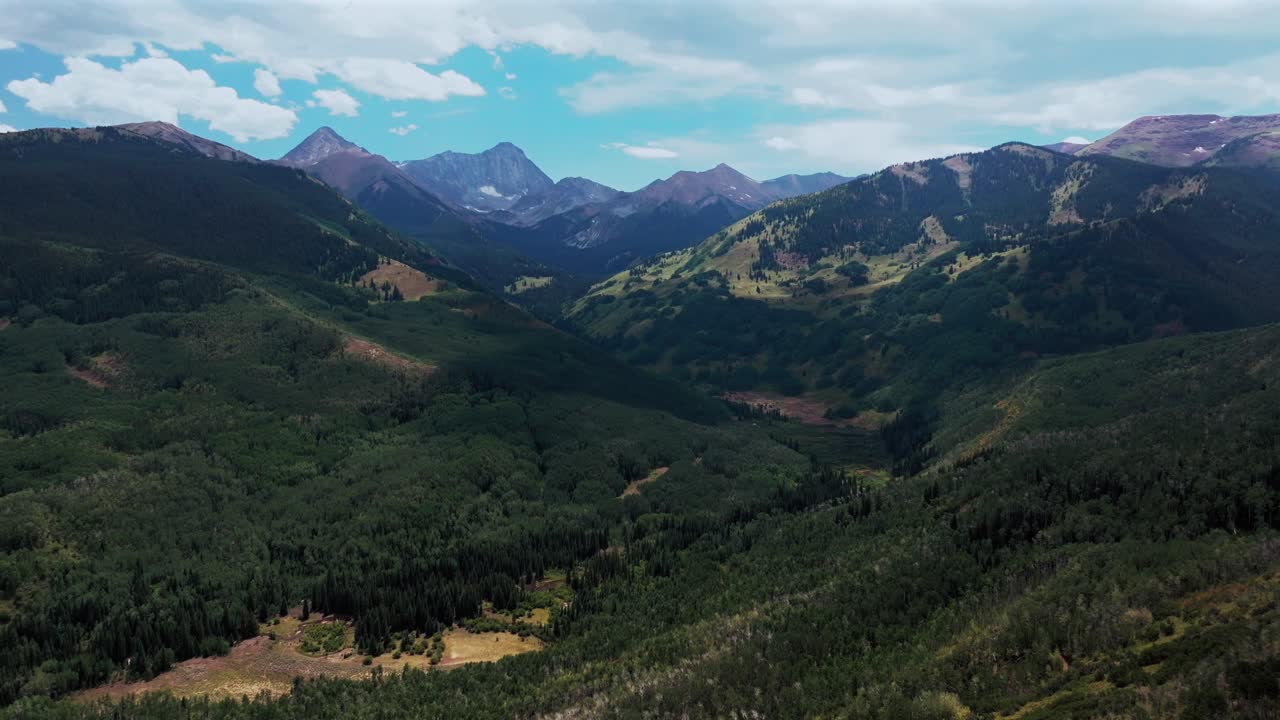 Capitol Peak Wilderness Capitol creek ditch trailhead spring summer 14er aerial drone Colorado Aspen Snowmass Elk Rocky Mountains Range Aspen grove White River Forest sunny blue sky forward pan up