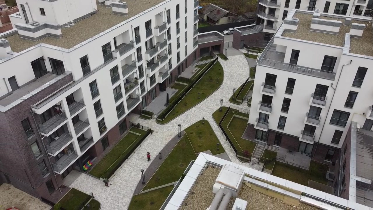 Vista aerea di un drone in volo sopra edifici residenziali, riprese di tetti e architettura.