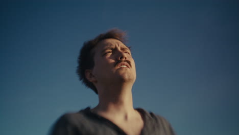 man looking up at the blue sky