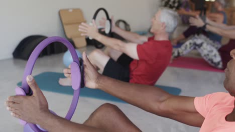 Focused-diverse-senior-people-exercising-with-circles-in-slow-motion