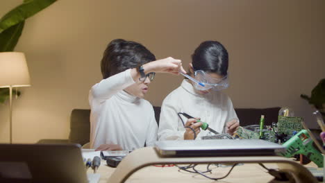 two smart modern kids in glasses doing project work