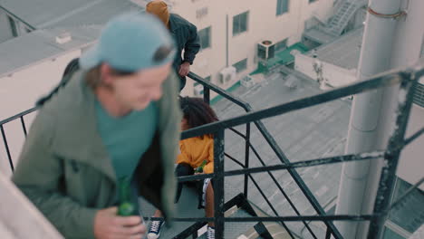 group of young multiracial friends walking up fire escape stairs to rooftop party chatting sharing excitement for weekend celebration