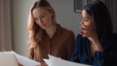 Two-women-working-together-at-home-office-about-new-project.