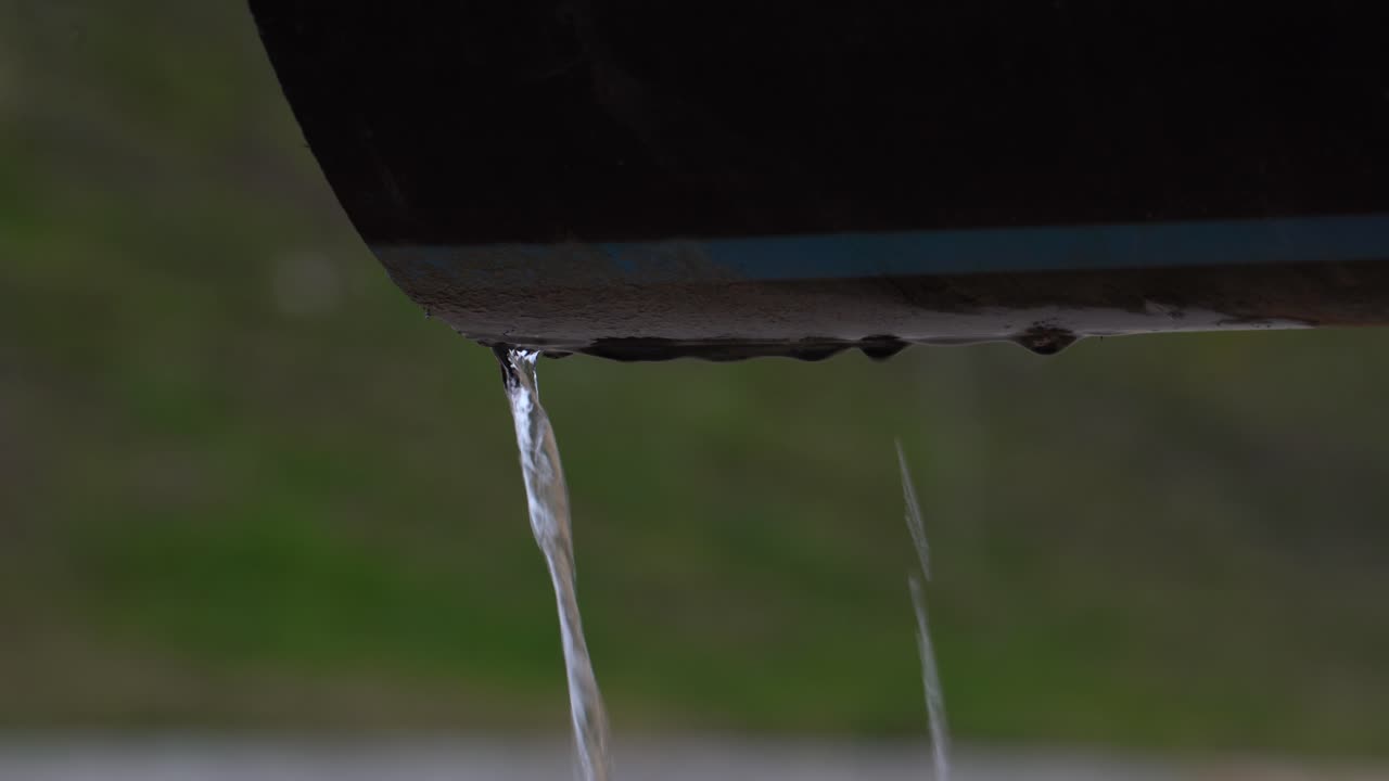 Dripping water flows from a large discharge pipe of polluted contaminated danger waste