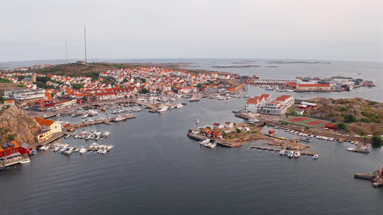 A picturesque view of a Norwegian harbor with colorful houses, boats, and rocky coast