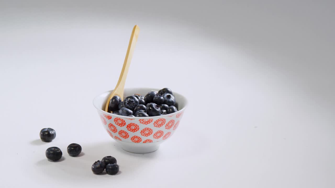 Blueberries in bowl with spoon placed on white background 4K 4k