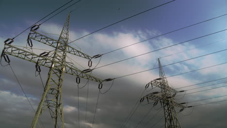 timelapse. floating clouds over high-voltage steel poles