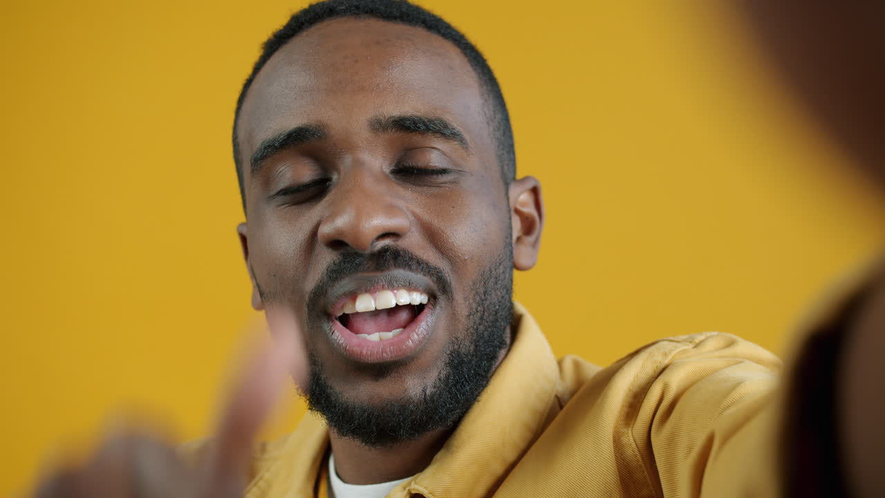 Man taking a selfie against a yellow background