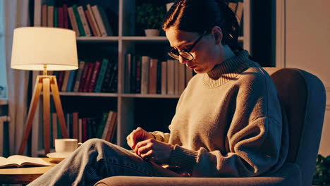 woman reading in a cozy library setting at night
