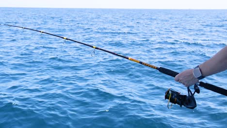 a person fishing from a boat in phuket, thailand. the scene captures the ocean, fishing rod, and serene atmosphere