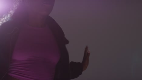 foto de estudio retroiluminada de una bailarina joven vestida casualmente bailando en el centro de atención