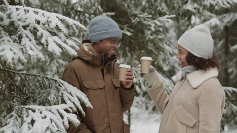 couple enjoying coffee in a snowy forest