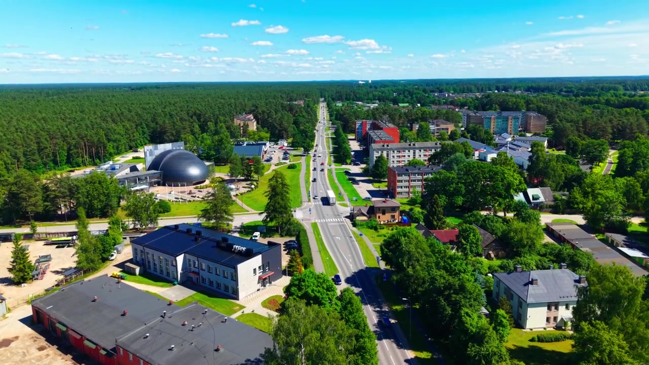 Letecký pohled na centrum města Ulbroka a hlavní silnici v Lotyšsku pod letní oblohou