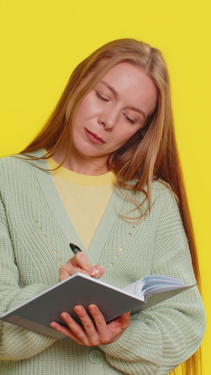 Woman making notes writing down thoughts with pen into notepad notebook diary to do list good idea