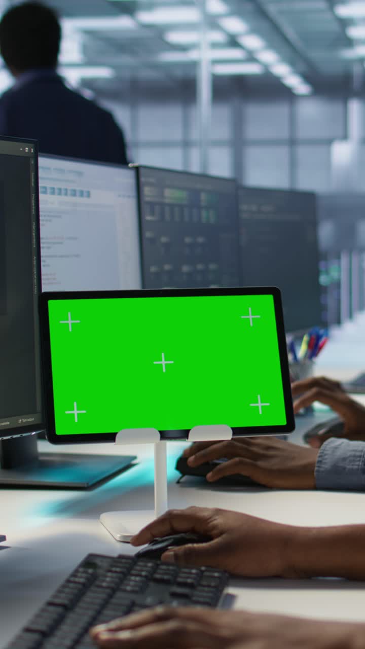 Vertical video Team of programmer using green screen tablet, working in server farm