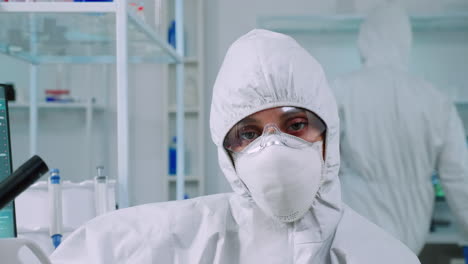 portrait of tired scientist in coverall looking at camera