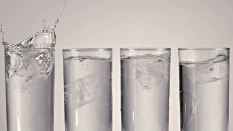 ice cubes falling into glass of water