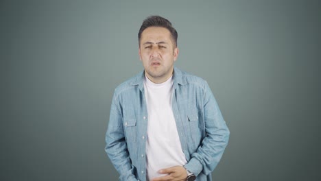 el hombre tiene dolor de estómago.