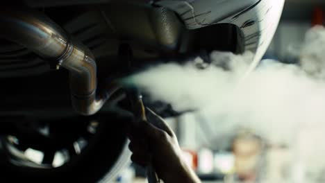 a mechanic works underneath a vehicle, focusing on detailed repairs with precision and care, highlighting the intricacies of automotive maintenance in a workshop setting